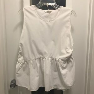 White sleeveless blouse with ruched sides.
